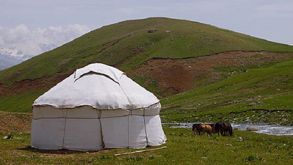 Paysage de Mongolie comportant une plaine, une yourte et des animaux des steppes